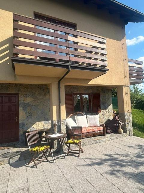 Covered patio under the balcony with sofa and chairs